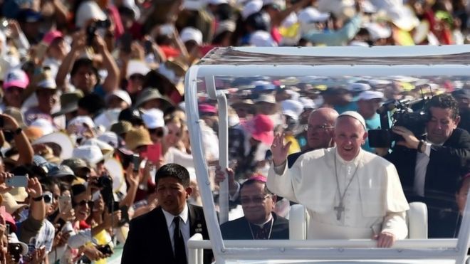 Папа Фрэнсис машет толпе, когда он прибывает на встречу с семьями на стадион Виктора Мануэля Рейны в Тустла Гутьеррес, штат Чьяпас (15 февраля 2016 года)