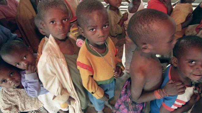 Дети-сироты Руанды выстраиваются в очередь за едой 17 июля 1994 года в старой французской школе в Кигали
