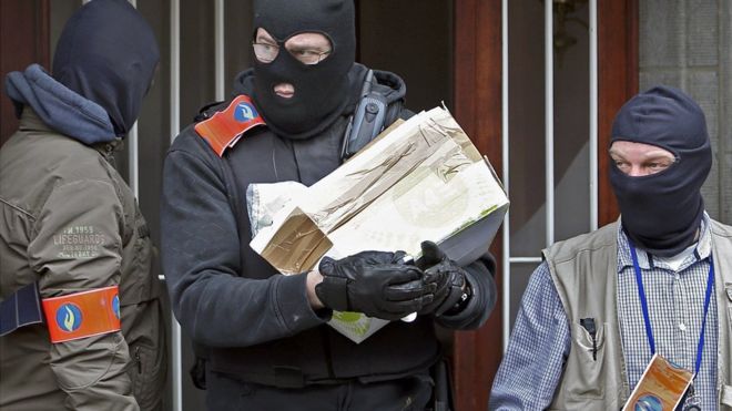 Бельгийская полиция в масках удаляет посылку из здания в Андерлехте во время обысков после нападений в Брюсселе - 23 марта 2016 года
