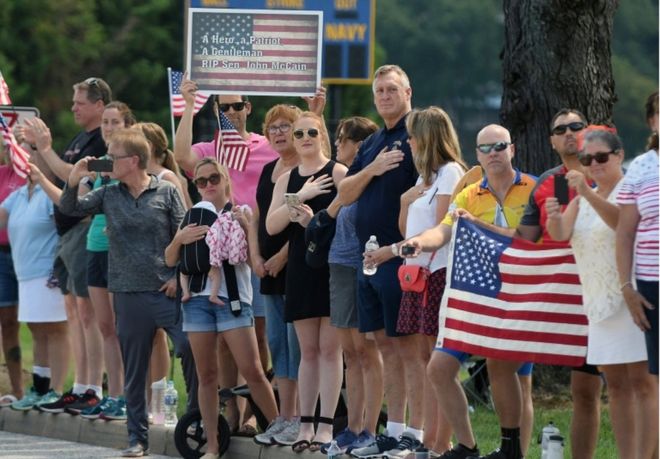 Зрители наблюдают, как катафалк с телом покойного сенатора Джона Маккейна прибывает на частную панихиду в Военно-морскую академию США в Аннаполисе