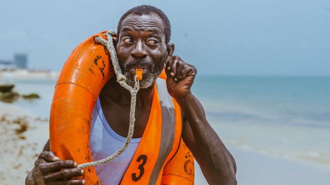 Спасатель Николас Пол насвистывает на пляже в Лагосе, Нигерия