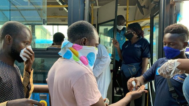 Les passagers embarquant dans un bus à Lagos reçoivent un désinfectant pour les mains