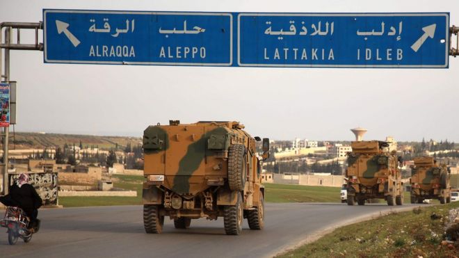Turkish military vehicles drive past the town of Atareb, Syria, as they head towards Idlib province (3 February 2020)
