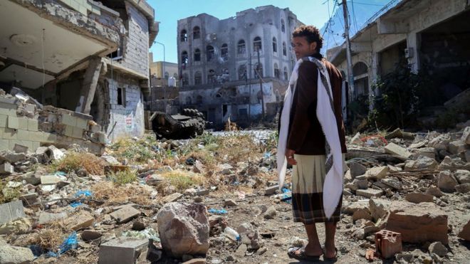 Йеменский мужчина осматривает ущерб на улице в Таизе после столкновений проправительственных боевиков и повстанцев-хути