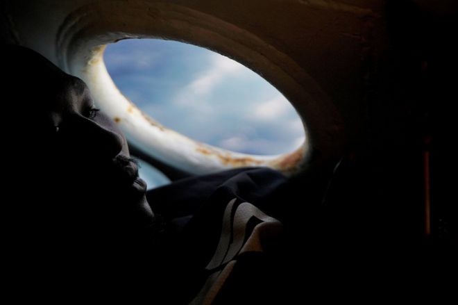 Мохамед, 21 год, из Судана, отдыхает на борту спасательной лодки общественной организации Proactiva Open Arms в центральной части Средиземного моря