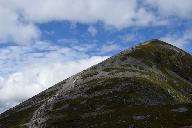 Паломники поднимаются и спускаются со святой горы Кроа Патрика во время ежегодного католического паломничества возле Леканви, Ирландия