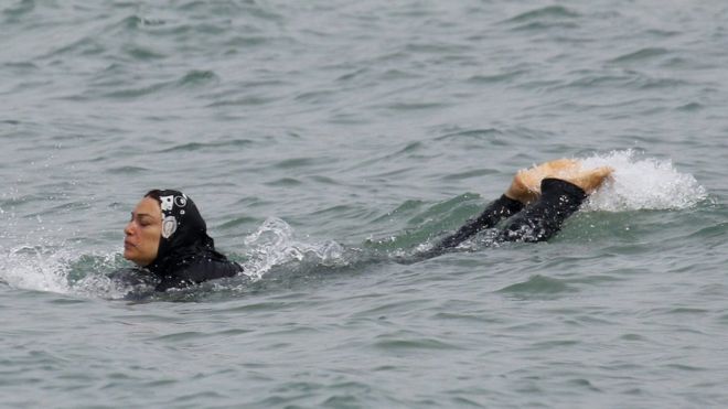 Мусульманская женщина носит буркини, купальник, который оставляет только лицо, руки и ноги открытыми, когда она плавает в Средиземном море в Марселе, Франция, 17 августа 2016 года.