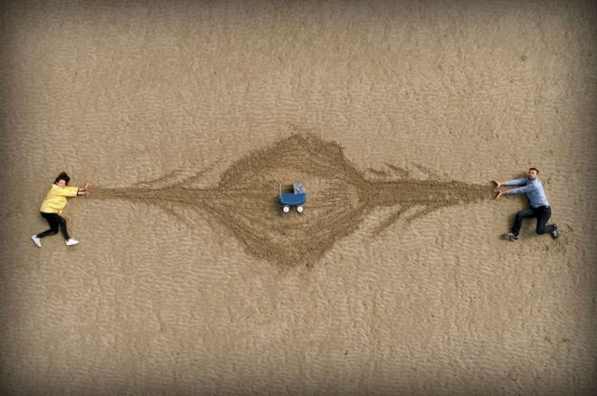 குழந்தை தள்ளுவண்டிக்கு அருகில் படுத்திருக்கும் ஒரு ஜோடி