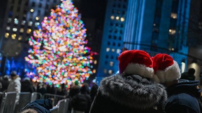 两名游客在美国纽约洛克菲勒中心圣诞树外