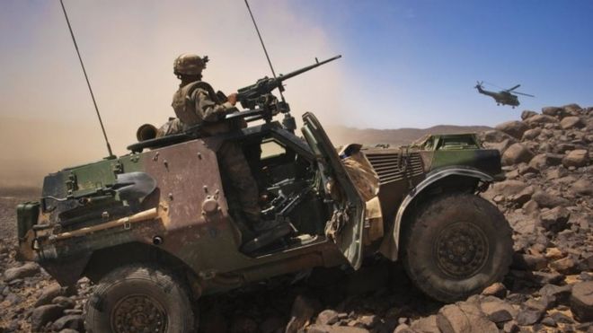 Французские солдаты стоят на страже в бронированной машине, вертолет покидает позиции в Мали. Файл фотографии