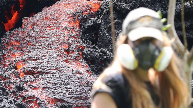 Una mujer camina junto a una fisura causada por la irupciÃ³n del volcÃ¡n Kilauea.