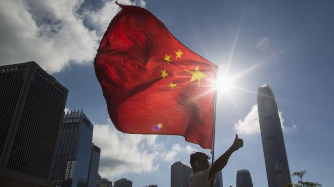 Китайский флаг перед горизонтом Гонконга