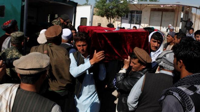 Родственники несут тело одной из жертв нападения талибов на афганскую военную базу