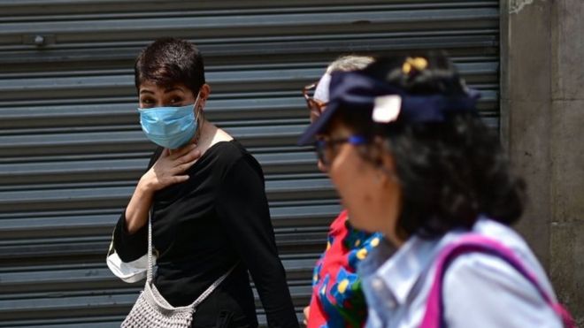 Люди носят маски из-за загрязнения воздуха, в центре города Мехико 14 мая 2019 года.