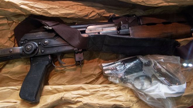 Штурмовая винтовка АК-47 и курносый пистолет показаны на коричневой бумаге