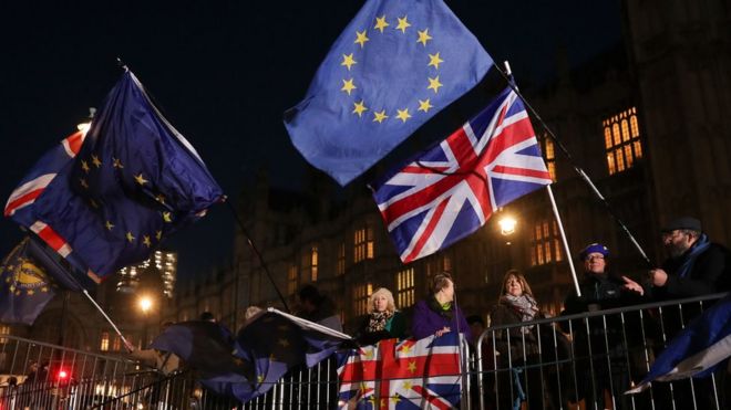 12 декабря 2018 года участники кампании по борьбе с брекситом развевают флаги Союза и ЕС возле здания Парламента в центре Лондона.