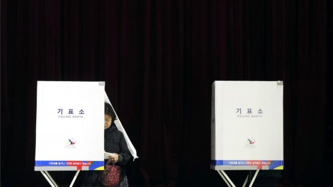 Южнокорейская женщина голосует на избирательном участке в Сеуле