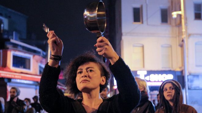 A woman in Istanbul bangs a saucepan to protest against the referendum result