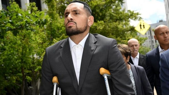 Nick Kyrgios arrives at court on crutches