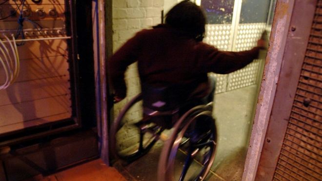 Человек в инвалидной коляске идет через дверной проем