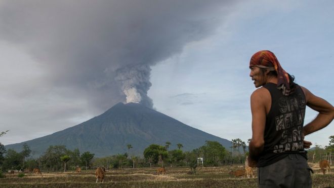 Hombre mira hacia el monte Agung, en alerta de erupción inminente.