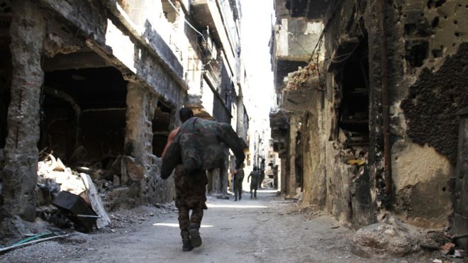 A man walks down a war-damaged street in the Yarmouk refugee camp in Damascus (6 April 2015)