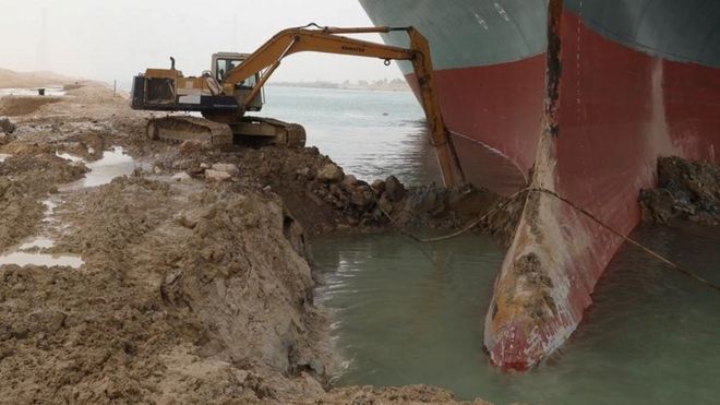 A digger attempts to remove earth around the bow of the Ever Given, which is blocking the Suez Canal, Egypt (25 March 2021)
