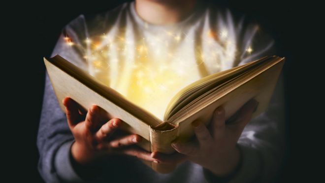 Un niños sostiene un libro del que salen luces