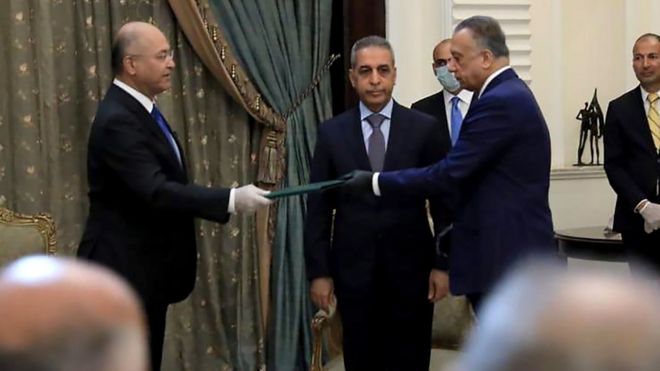 President Barham Saleh (L) and Mostafa al- (R) wore gloves at the ceremony