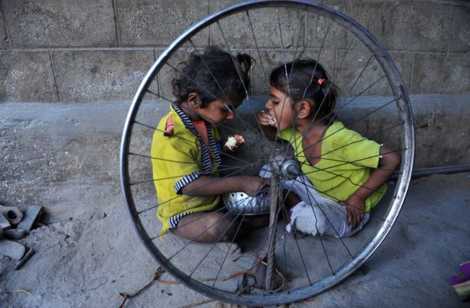 Two children eat at a temporary shelter