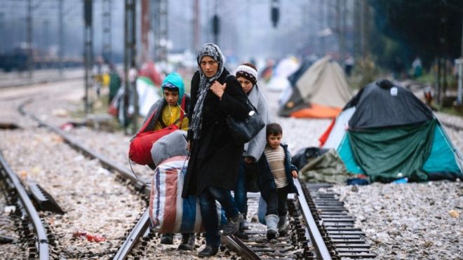 9 марта 2016 года женщина и трое детей идут по железнодорожным путям, соединяющим Грецию с Западной Европой на греко-македонской границе у греческой деревни Идомени.