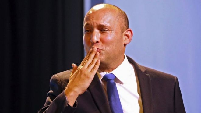 Naftali Bennett, leader of the Israeli right-wing Yamina ('New Right') party, blows kisses as he greets supporters at his party's campaign headquarters
