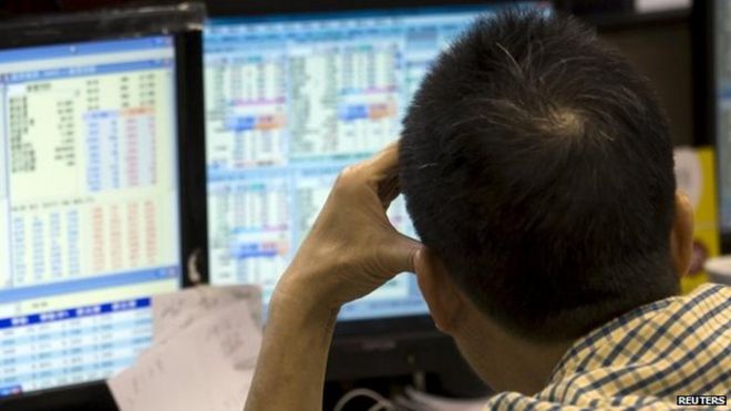 Инвестор отслеживает цены акций внутри брокерской фирмы во время утренних торгов в Гонконге
