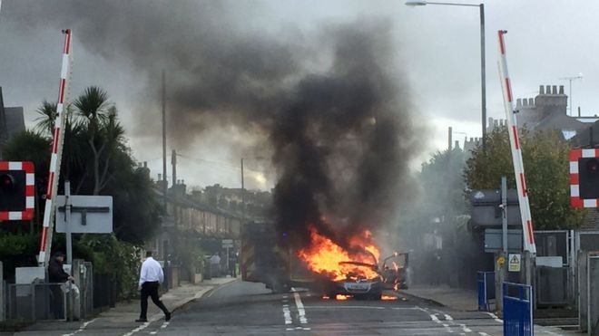 Автомобиль Vauxhall в огне возле железнодорожной переезда в Лондоне