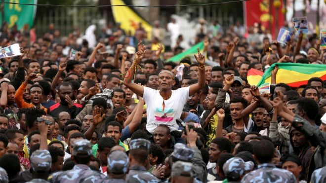 Протестующие выступают перед федеральными полицейскими во время акции протеста после церемонии захоронения Симегнева Бекеле, менеджера проекта Эфиопии по Великой Ренессансной плотине