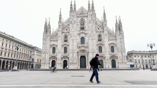 A man walks in Duomo square in Milan