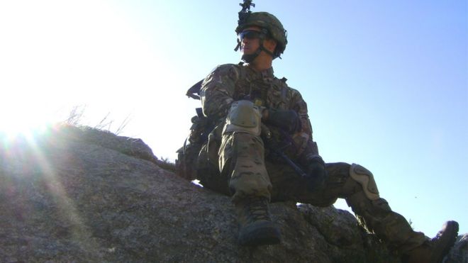 Джозеф Лоус в униформе сидит на скале