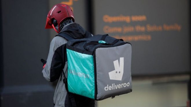 Наездник Deliveroo делает доставку в Лондон.