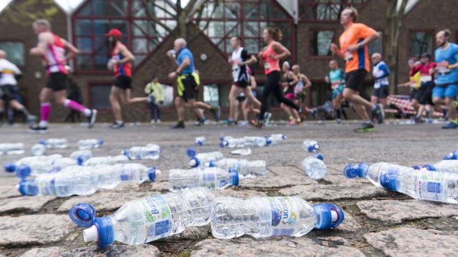 Бегуны проходят мимо бутылок с водой во время участия в Лондонском марафоне 2016 года в Лондоне