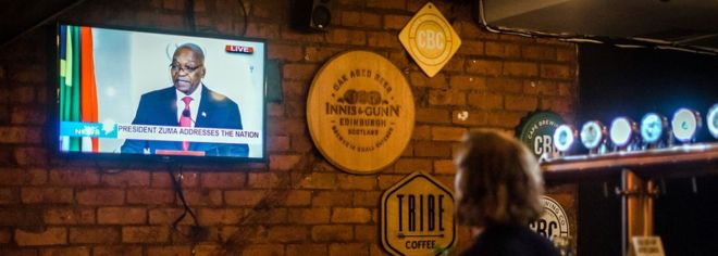 Посетители в баре в Дурбане наблюдают, как президент ЮАР Джейкоб Зума подает в отставку во время выступления 14 февраля 2018 года