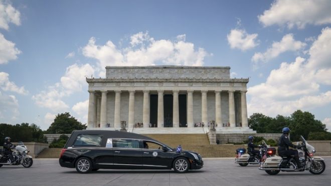Катафалк, несущий задрапированный флагом гроб с телом члена палаты представителей Джона Льюиса (штат Джорджия), останавливается перед мемориалом Линкольна перед тем, как отправиться в Капитолий США, где он будет лежать 27 июля 2020 года в Вашингтоне, округ Колумбия || |