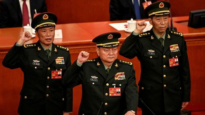 Zhang Youxia (C), newly-elected Vice Chairman of the Central Military Commission of the People's Republic of China, swears an oath with Central Military Commission members He Weidong and Li Shangfu after they were elected