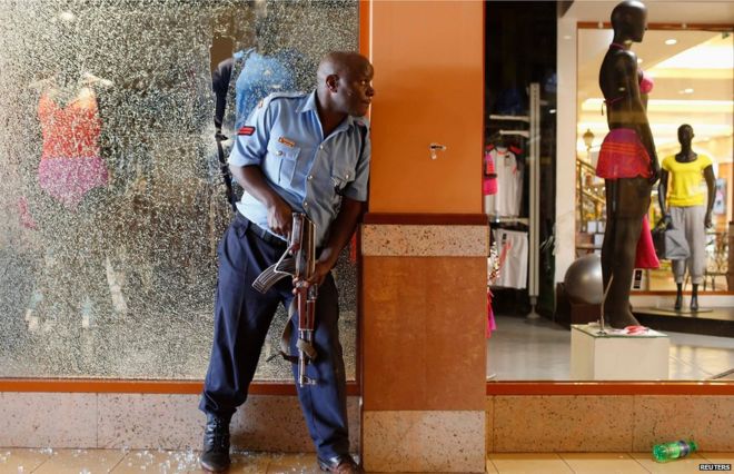 Полицейский пытается обезопасить территорию внутри торгового центра Westgate, где 21 сентября 2013 года стрельба началась в Найроби.