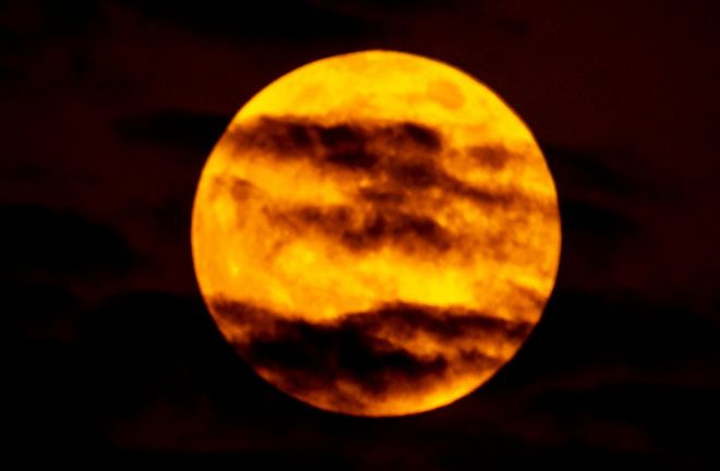Снимок крови человека, снятого в Дубае, ОАЭ, показывает красные облака на ярко-оранжевой луне