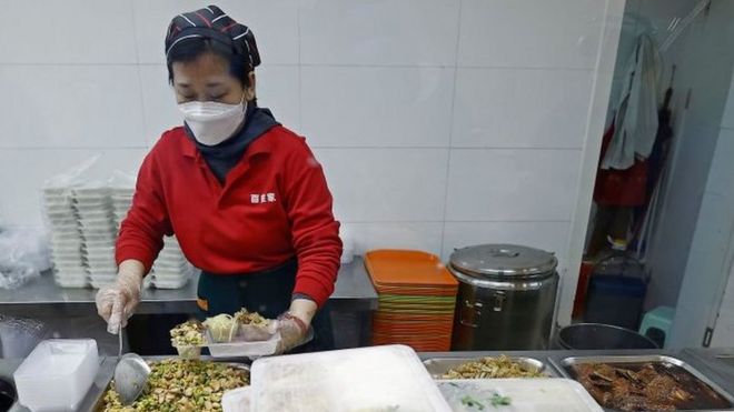 Mujer sirve comida en un asilo