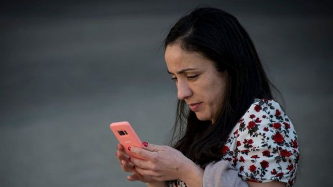 Mujer usando un celular en Santiago de Chile