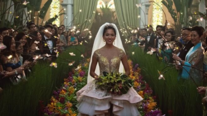 Кадр из фильма «Сумасшедшие богатые азиаты», показывающий, как Соноя Мизуно идет по проходу в свадебном платье