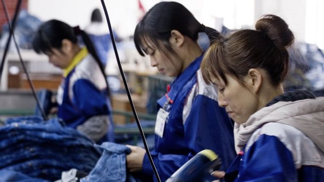Women sew jeans at a factory in China