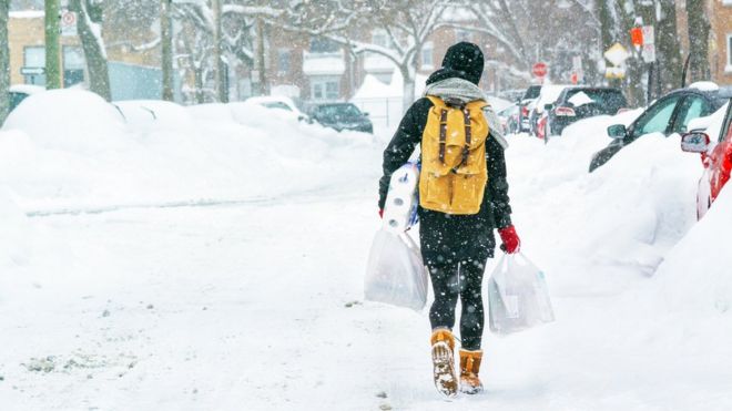 Женщина с покупками в снегу