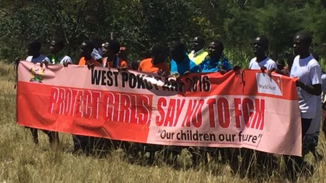 Группа мужчин держит плакат с надписью: «Округ Покот - скажи« нет »FGM - нашим детям наше будущее